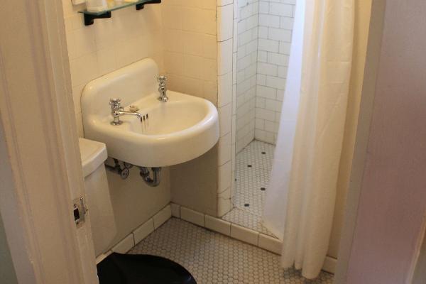 The toilet room features original fixtures, tilework, and step-in shower.