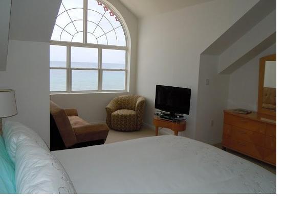 Top floor bedroom with sitting area and ocean view