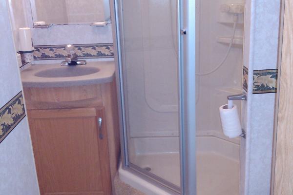 Full Bathroom with corner shower, toilet, sink, vanity/mirror
