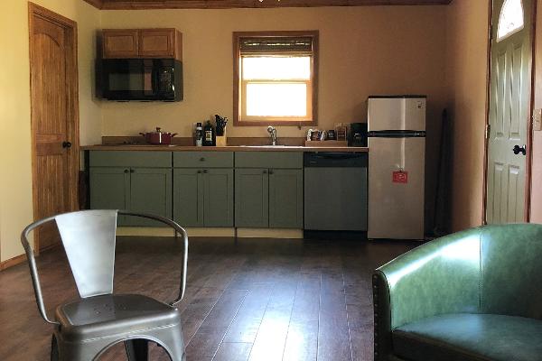 The kitchen area features a fridge, dishwasher, cook top and microwave. 