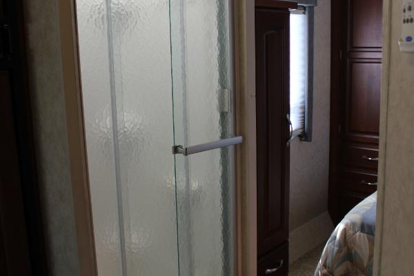 Stand-up Shower across from bathroom with glass doors